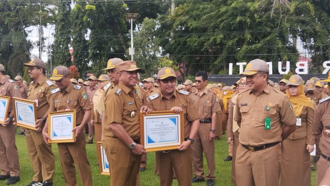 
					Ket.Wakil Bupati Tanah Laut, HM Zazuli, disela apel gabungan menyerahkan penghargaan di halaman Kantor Bupati Tanah Laut pada Senin (23/02/2026). foto.Ariyani