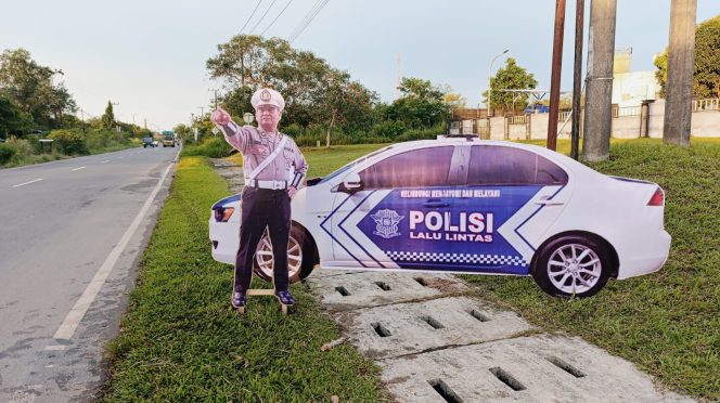 
					Ket.Replika mobil patroli dan figur anggota polisi lalu lintas dipasang Satlantas Polres Tanah Laut di salah satu titik rawan kecelakaan. Foto.Ist