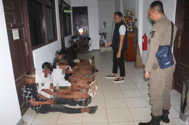 
					Personel Satpol PP Tanah Laut mengamankan remaja pesta miras di RTH Kijang Mas. (SANAK.ID/Ist) 