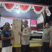 Kapolsek Pulau Sembilan IPTU Agus Riyanto menyerahkan hadiah lomba domino Hari Bhayangkara ke-80. (SANAK.ID/RYAN WARDANI) 