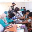 Petugas kesehatan sedang membagikan masker dan memeriksa kondisi pernapasan warga di halaman Mapolsek Bati Bati. (SANAK.ID/Dok.Humas Polres)